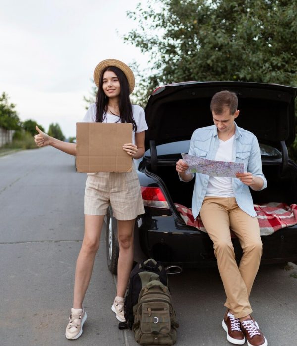 front-view-young-couple-hitch-hiking-holiday_23-2148691116